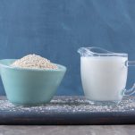 blue-bowl-rice-with-glass-cup-milk-wooden-board